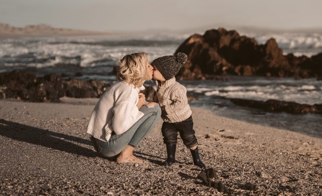 woman embracing toddler on beach newport beach getaways resolution blog